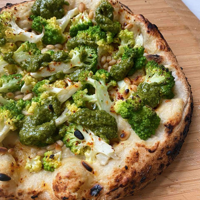 Pizza au chou romanesco avec crème de cajou, sauce verte et pignons de pin