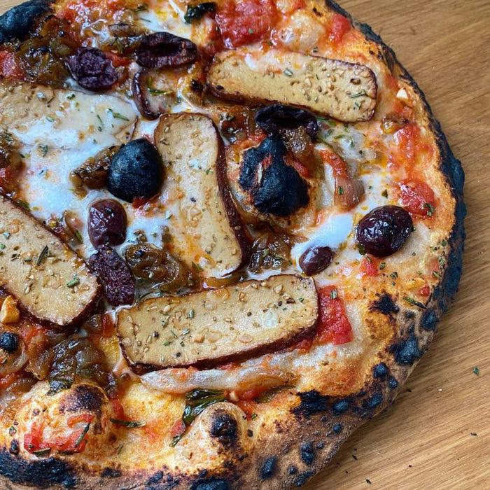 Pizza au tofu fumé et aux oignons caramélisés avec feta vegan, olives et romarin