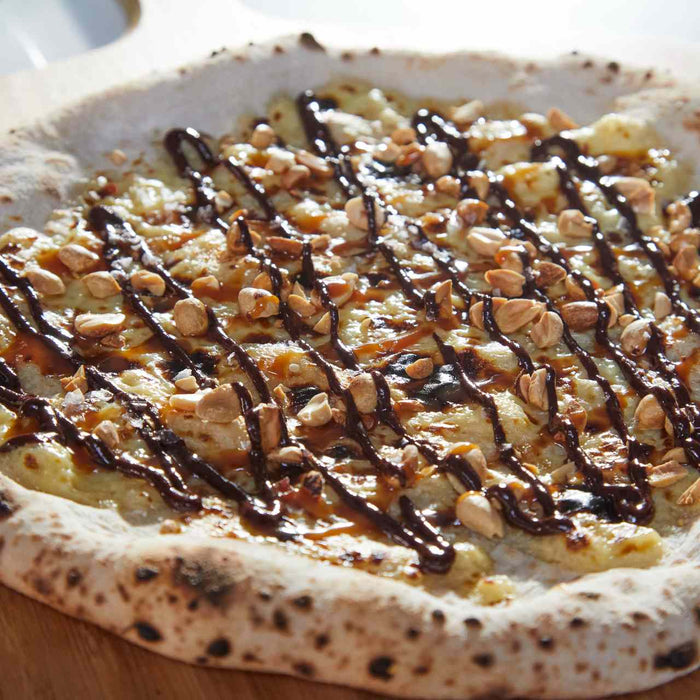 Pizza “barre chocolatée” aux cacahuètes, caramel et chocolat fondu